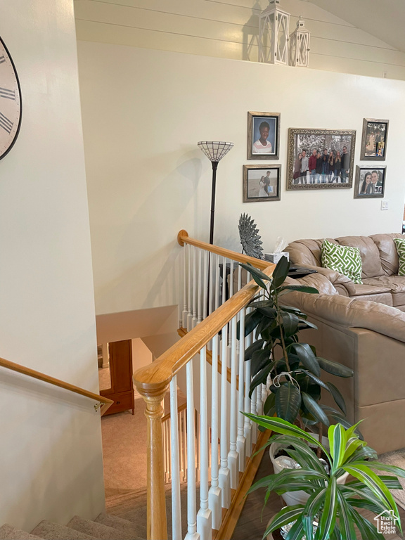 Stairway with carpet and vaulted ceiling
