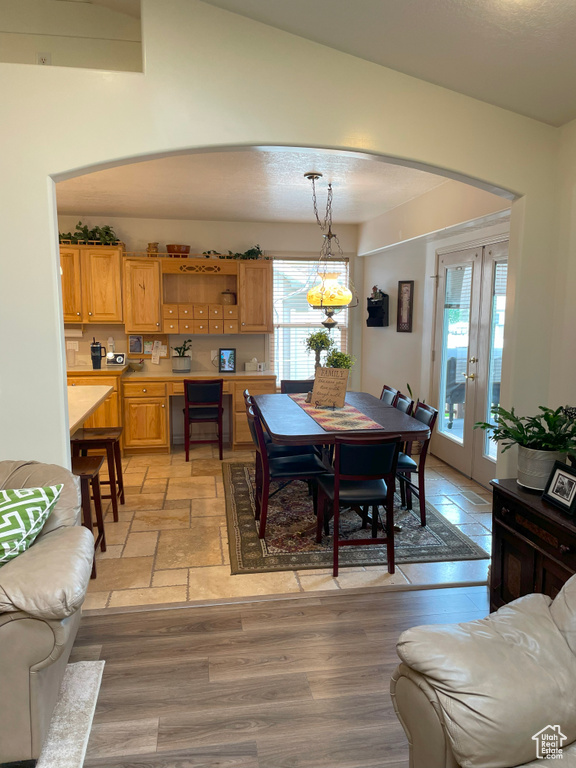 Dining area featuring a chandelier, french doors, arched walkways, and vaulted ceiling