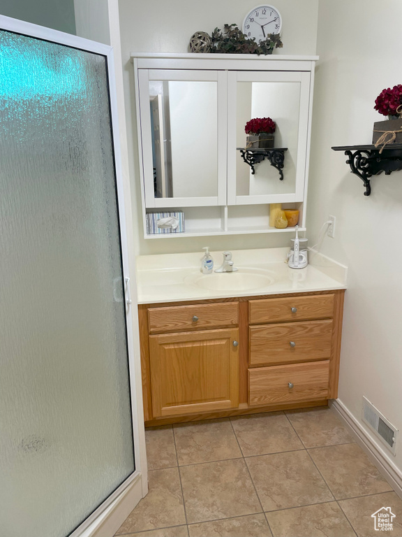 Bathroom with tile patterned floors, a stall shower, and vanity