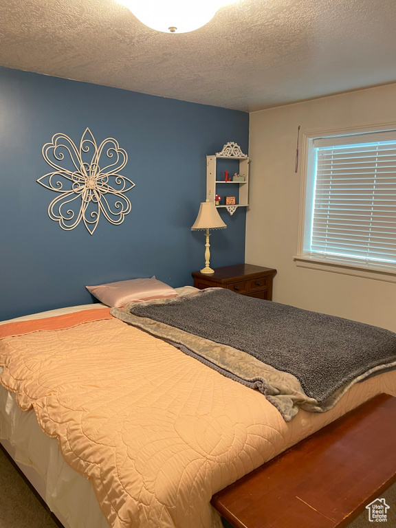 Bedroom featuring carpet floors and a textured ceiling