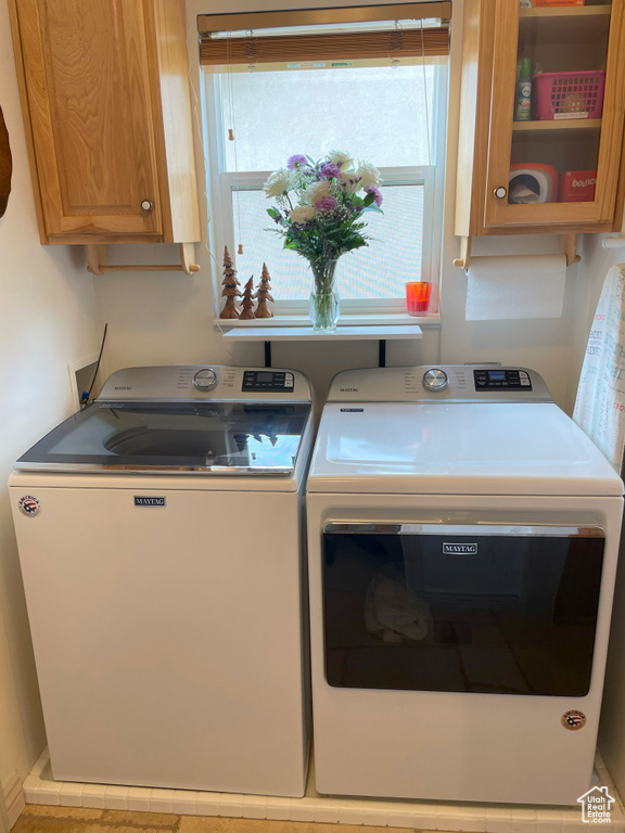 Washroom featuring cabinet space and washing machine and clothes dryer