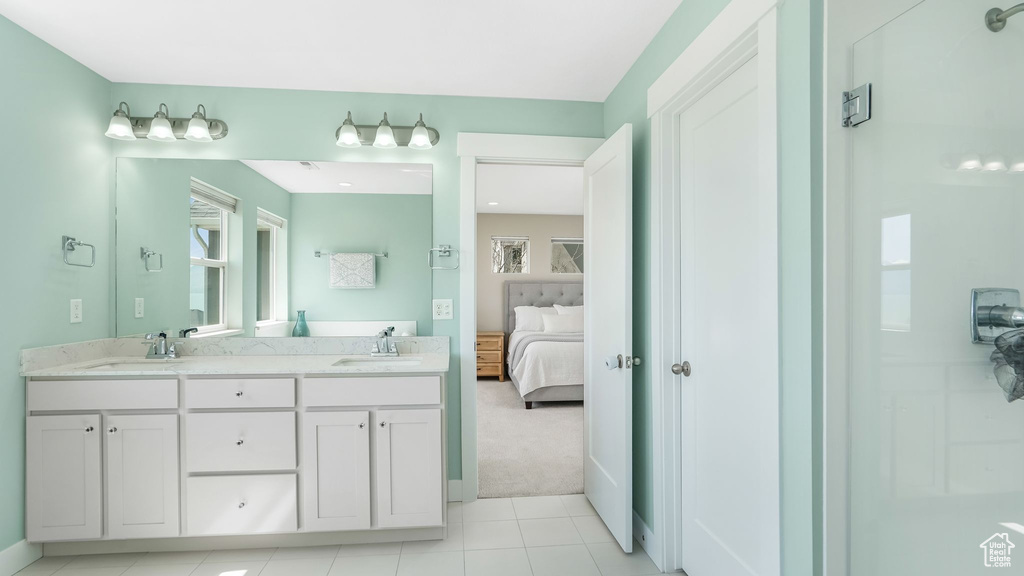 Ensuite bathroom with plenty of natural light, double vanity, and tile patterned floors