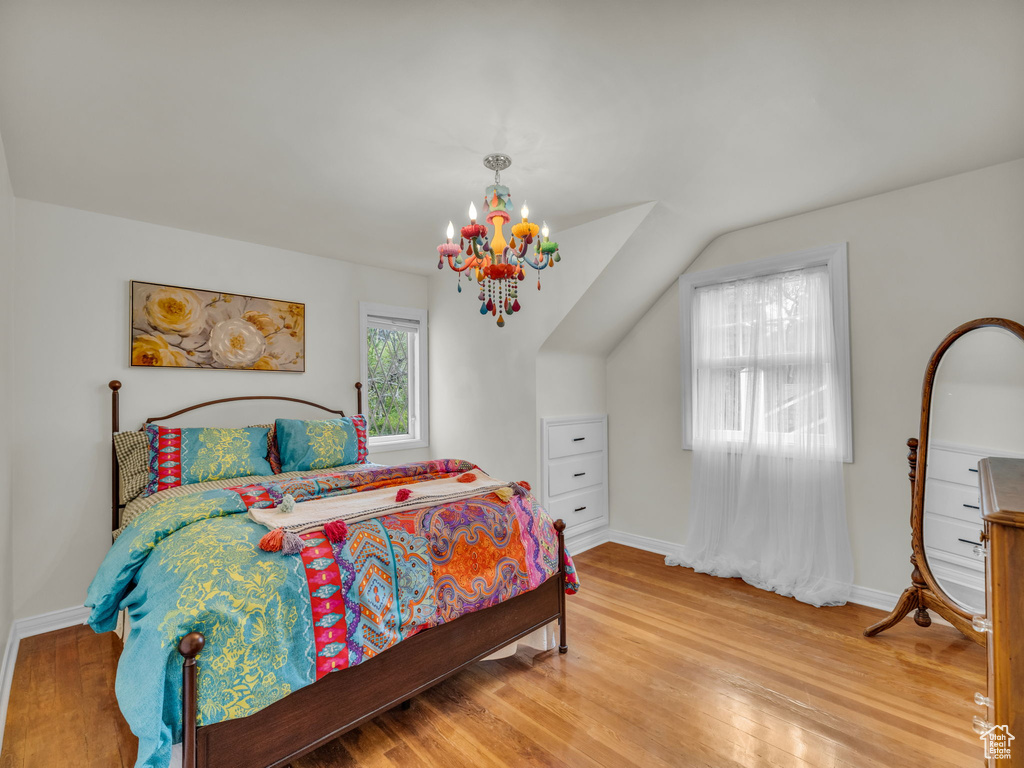 Bedroom featuring wood finished floors, baseboards, and a chandelier
