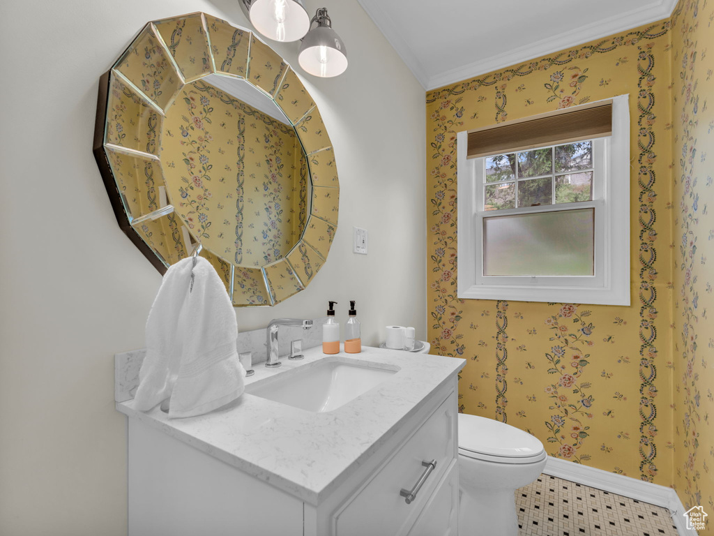 Bathroom featuring ornamental molding, toilet, vanity, and baseboards