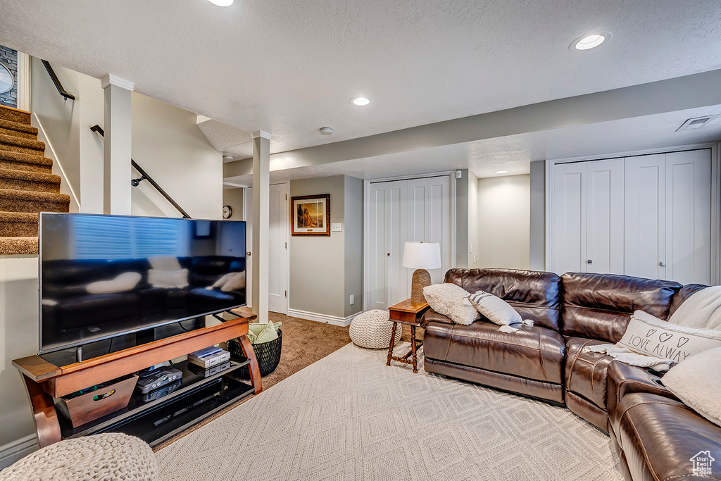 Living area featuring recessed lighting, baseboards, stairs, and carpet