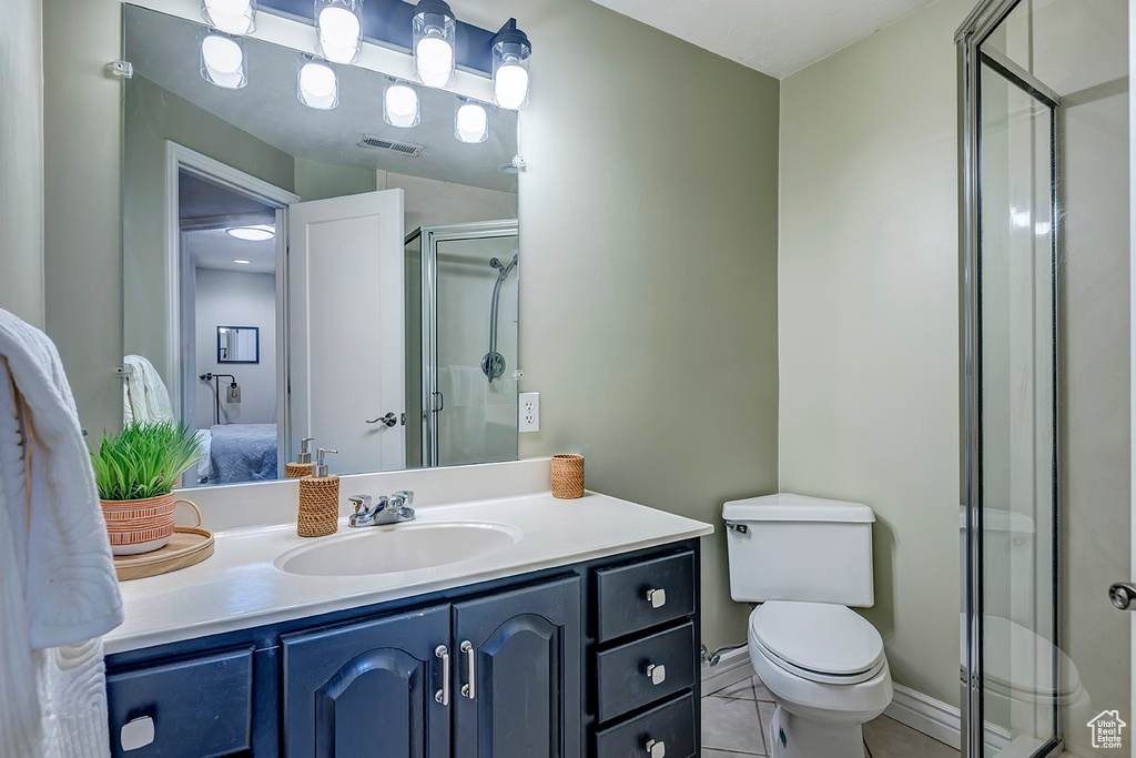 Full bath featuring a stall shower, vanity, ensuite bathroom, and toilet