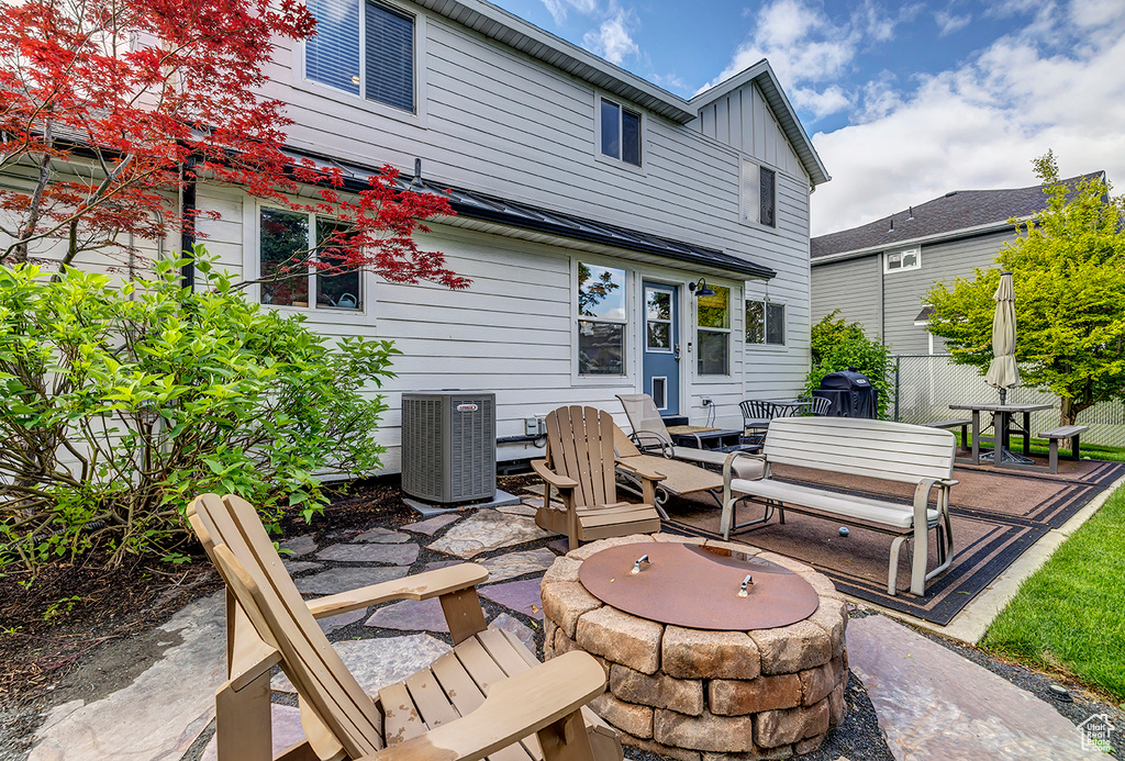 Rear view of house featuring an outdoor fire pit, central AC, a patio, and board and batten siding
