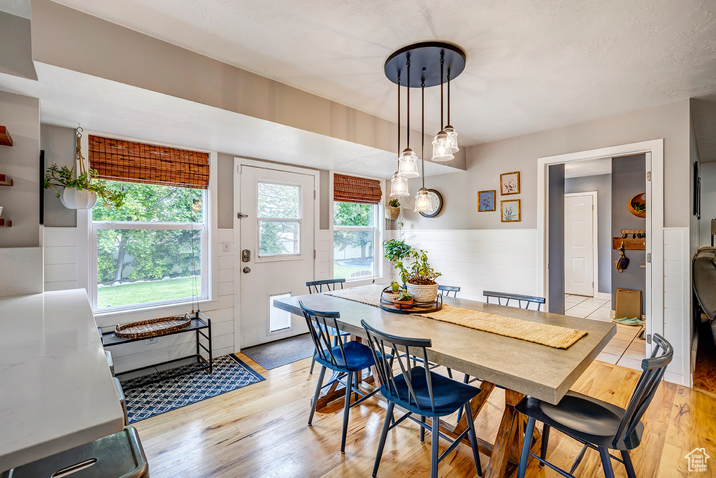 Dining area featuring light wood-style flooring and wainscoting