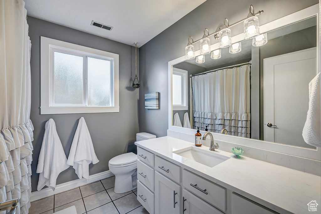 Full bath with tile patterned flooring, toilet, vanity, and baseboards