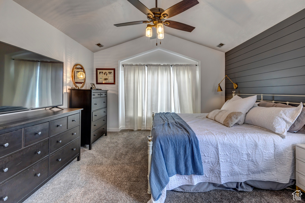 Bedroom with lofted ceiling, light colored carpet, and ceiling fan