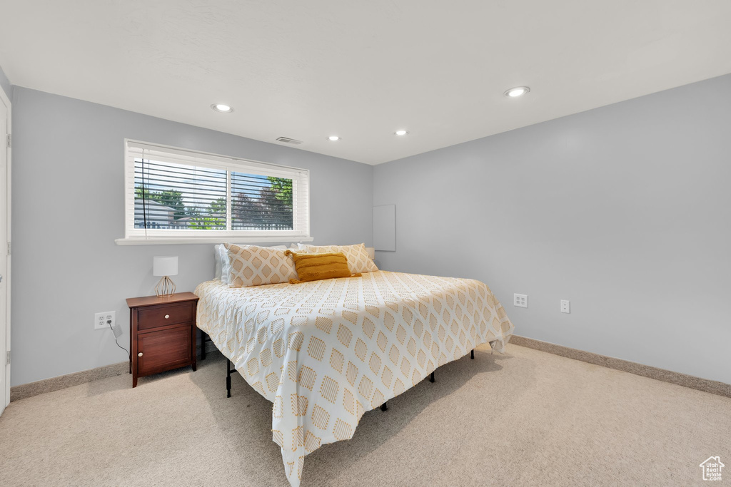 Bedroom with light colored carpet, recessed lighting, and baseboards