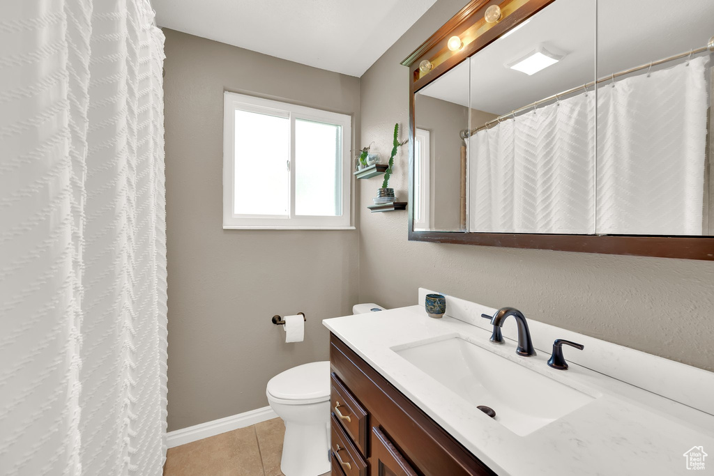 Full bathroom featuring toilet, tile patterned floors, vanity, and baseboards
