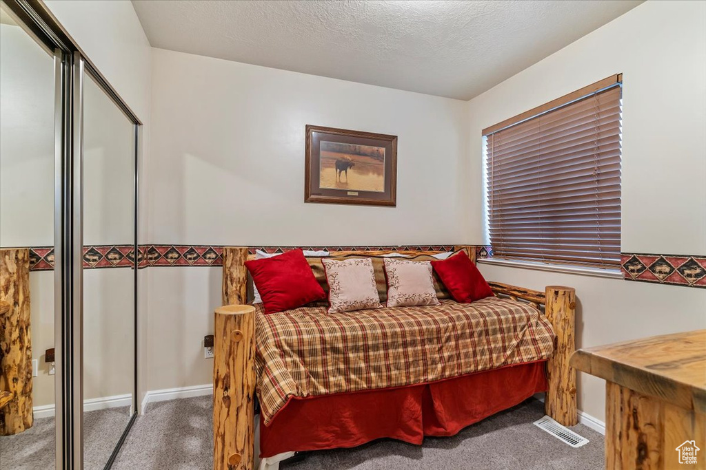 Bedroom featuring carpet flooring, baseboards, and a closet