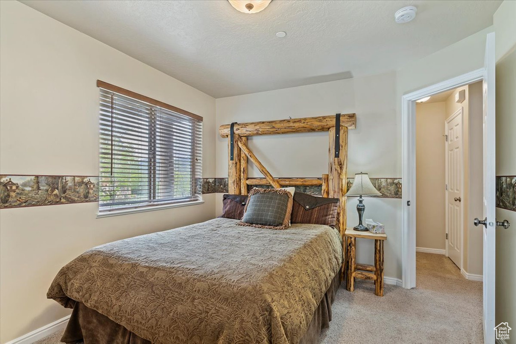 Bedroom featuring carpet and baseboards