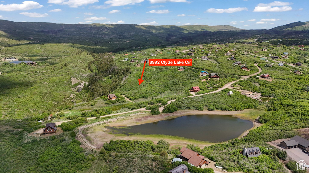 Aerial view of property and surrounding area with a water and mountain view