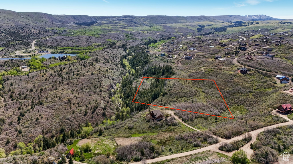 Aerial view of property and surrounding area with property parcel outlined and a water and mountain view