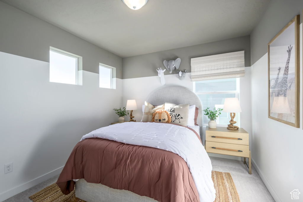 Bedroom featuring light carpet and baseboards