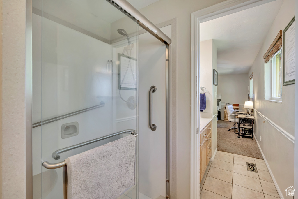 Bathroom featuring a stall shower, tile patterned flooring, and vanity
