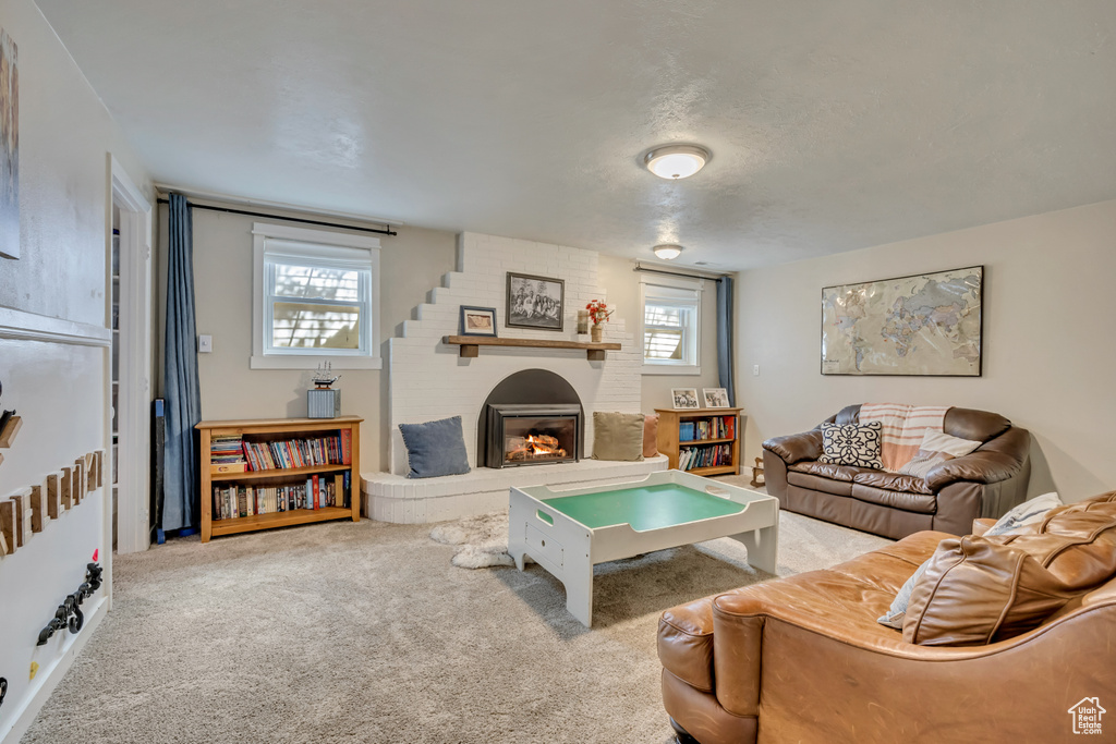 Carpeted living area featuring a brick fireplace
