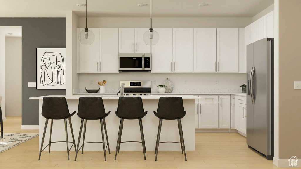 Kitchen featuring stainless steel appliances, white cabinetry, light wood-type flooring, and light countertops