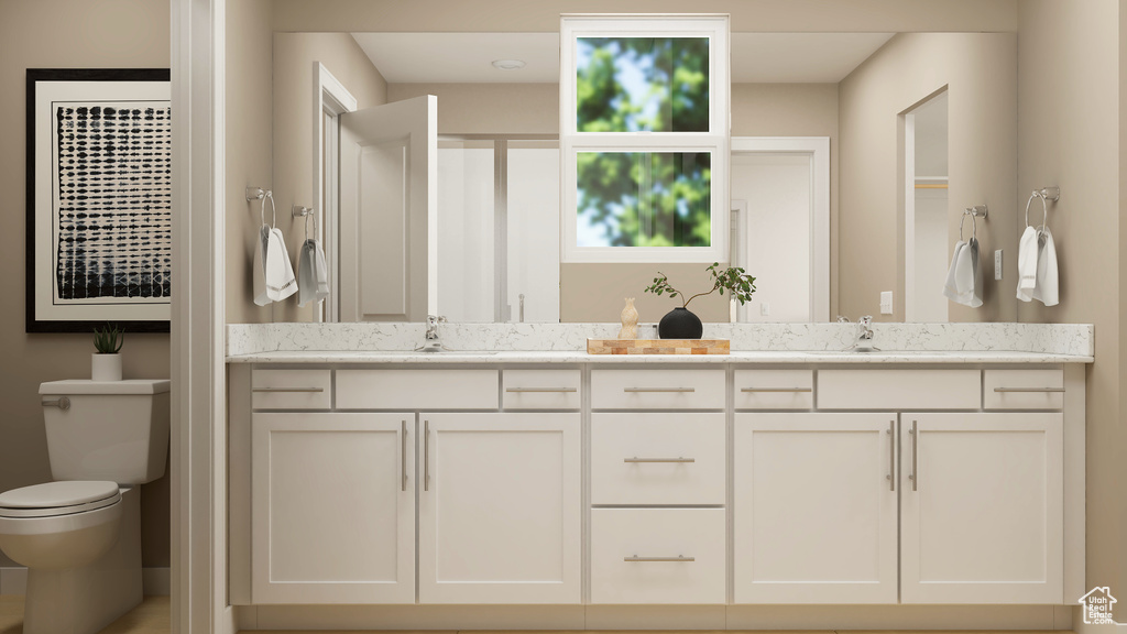 Full bathroom featuring toilet and double vanity