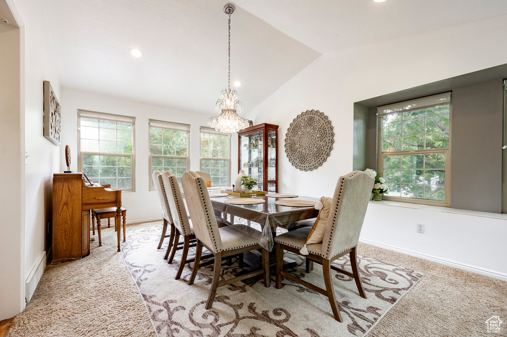 Dining area featuring a chandelier, vaulted ceiling, light carpet, baseboards, and recessed lighting