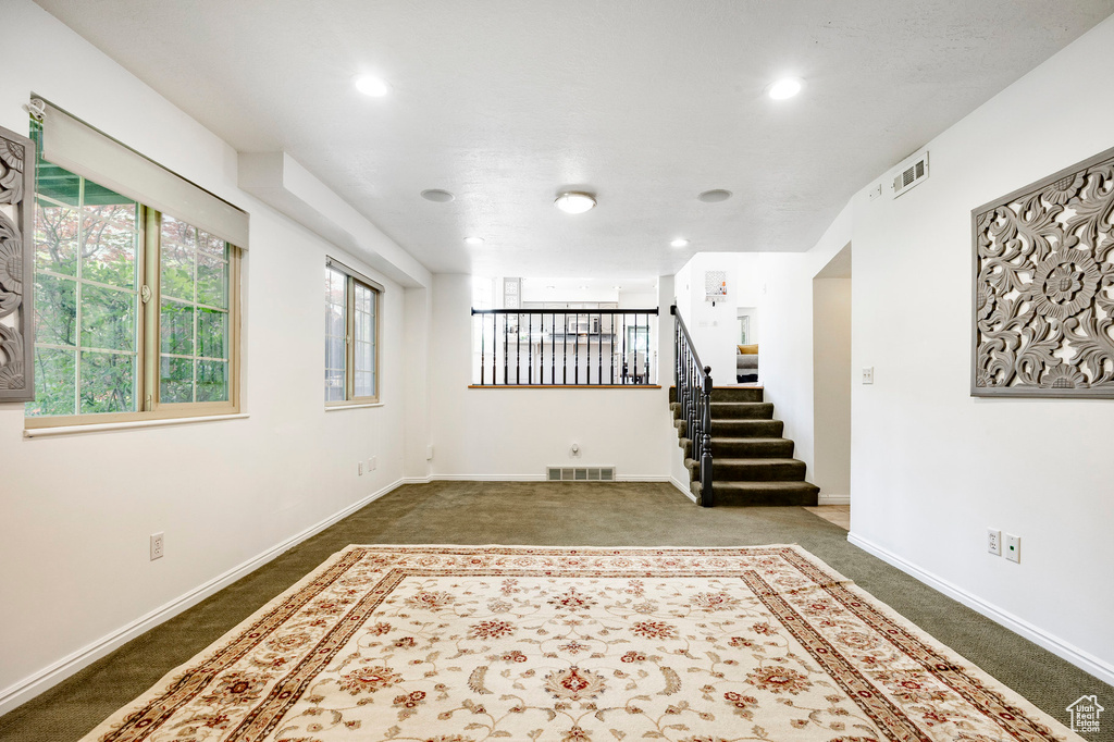 Carpeted spare room featuring healthy amount of natural light, recessed lighting, stairs, and baseboards