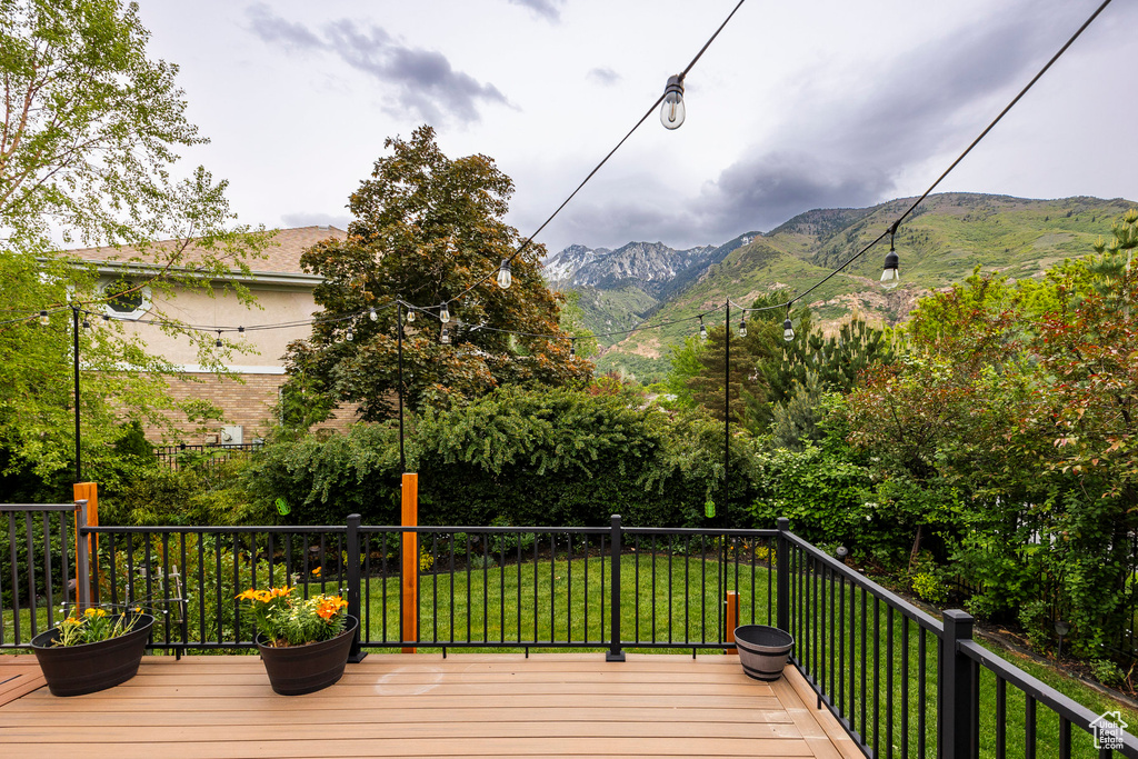 Wooden deck with a mountain view and a yard