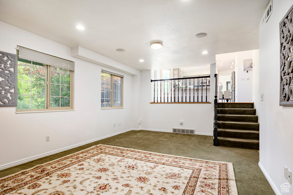 Carpeted spare room with healthy amount of natural light, baseboards, stairs, and recessed lighting