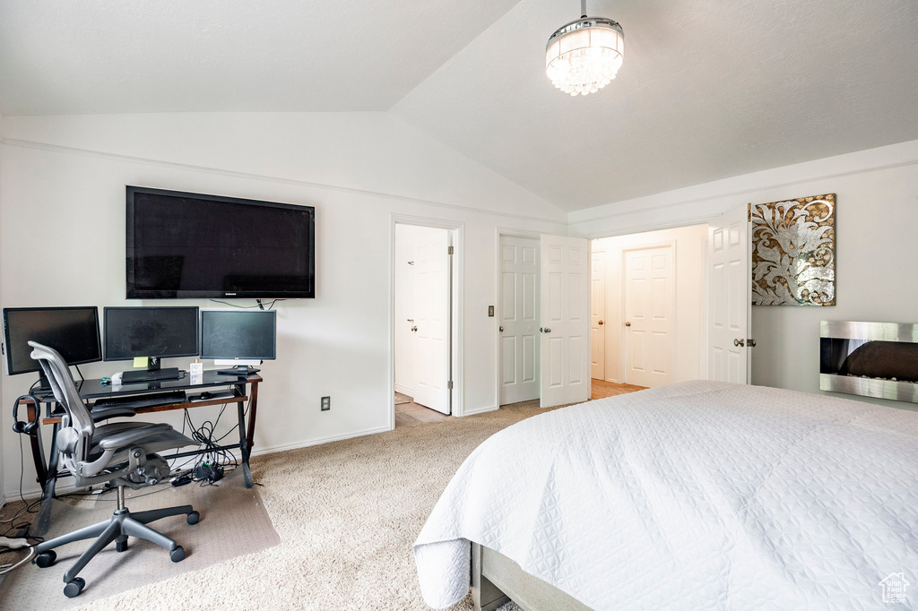 Bedroom featuring vaulted ceiling, carpet, baseboards, and an office area
