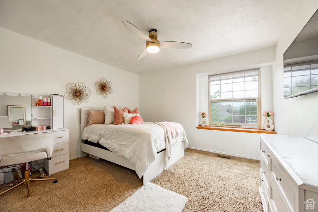 Bedroom featuring light carpet, ceiling fan, baseboards, and an office area