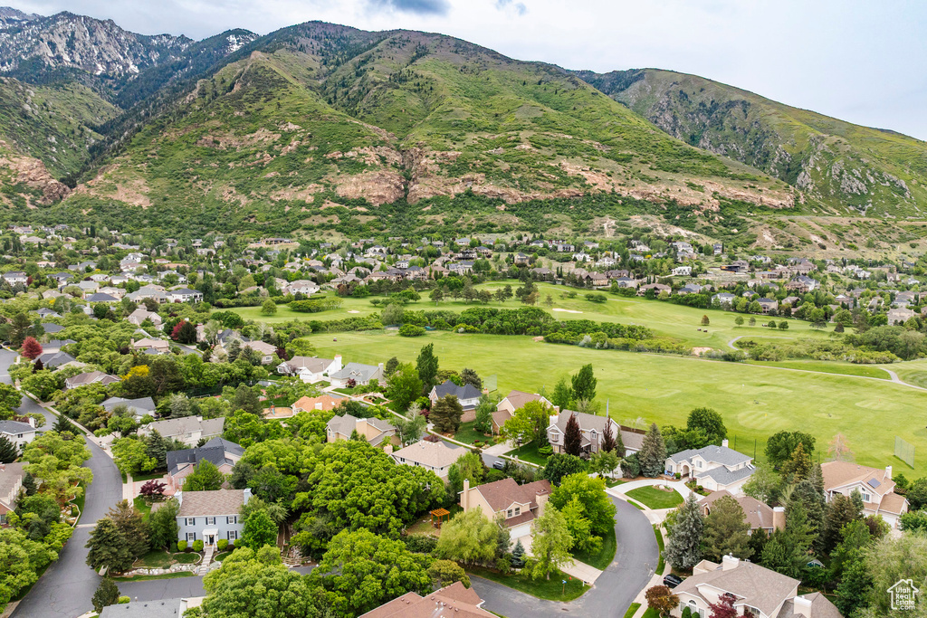Aerial view of residential area with a mountainous background and a golf club