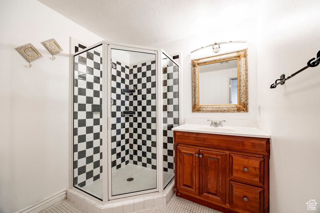 Bathroom with a shower stall, vanity, and tile patterned floors