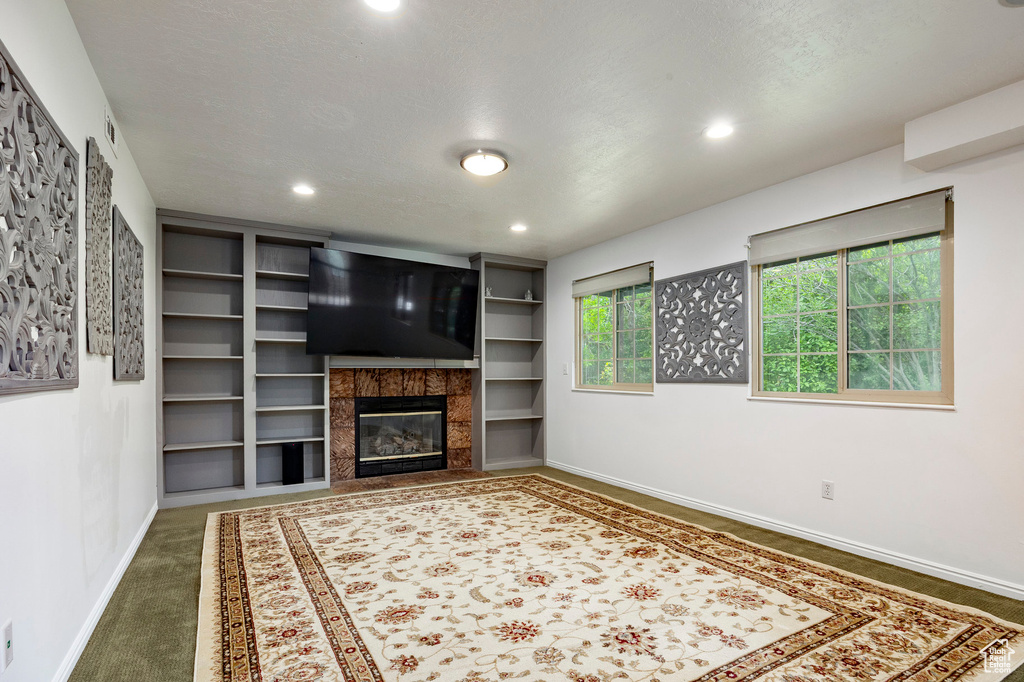 Unfurnished living room with baseboards, a high end fireplace, carpet floors, and recessed lighting