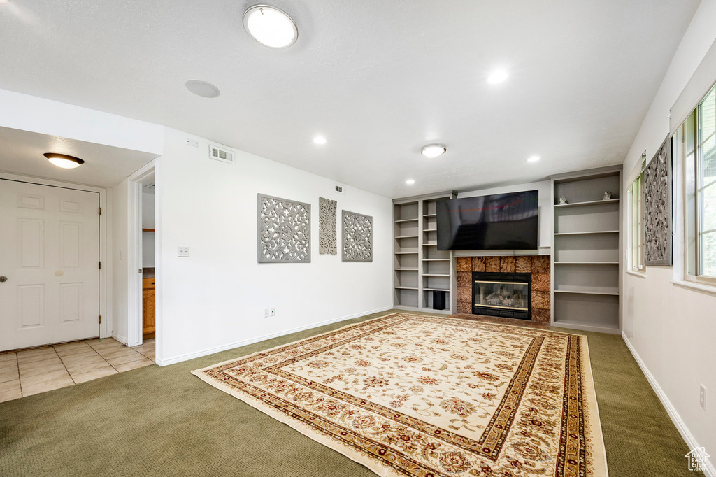 Living area featuring carpet floors, a tile fireplace, baseboards, and recessed lighting
