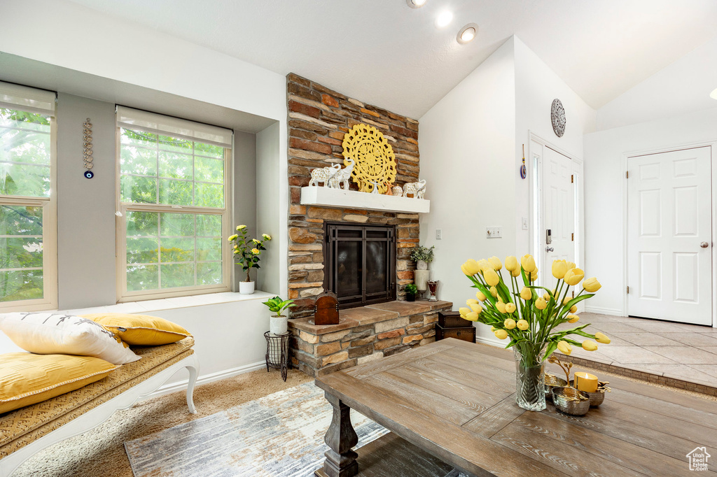 Living area with vaulted ceiling, a fireplace, and baseboards