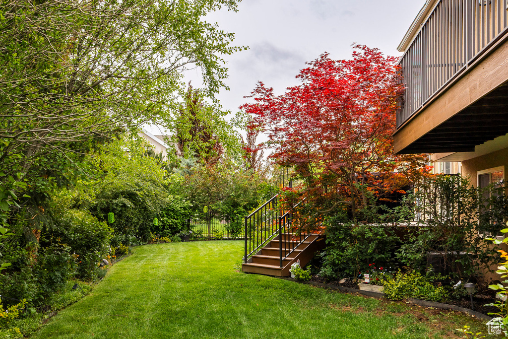 View of grassy yard featuring stairs
