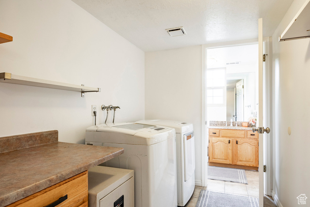 Laundry room featuring washing machine and dryer and light tile patterned flooring