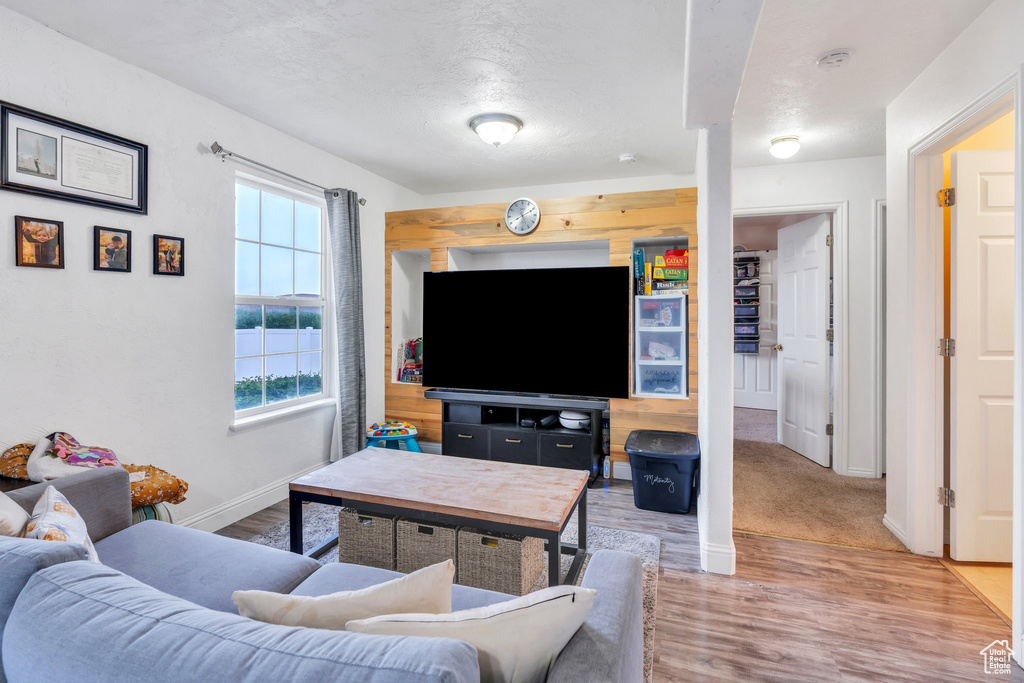 Living room with healthy amount of natural light, light wood finished floors, and baseboards