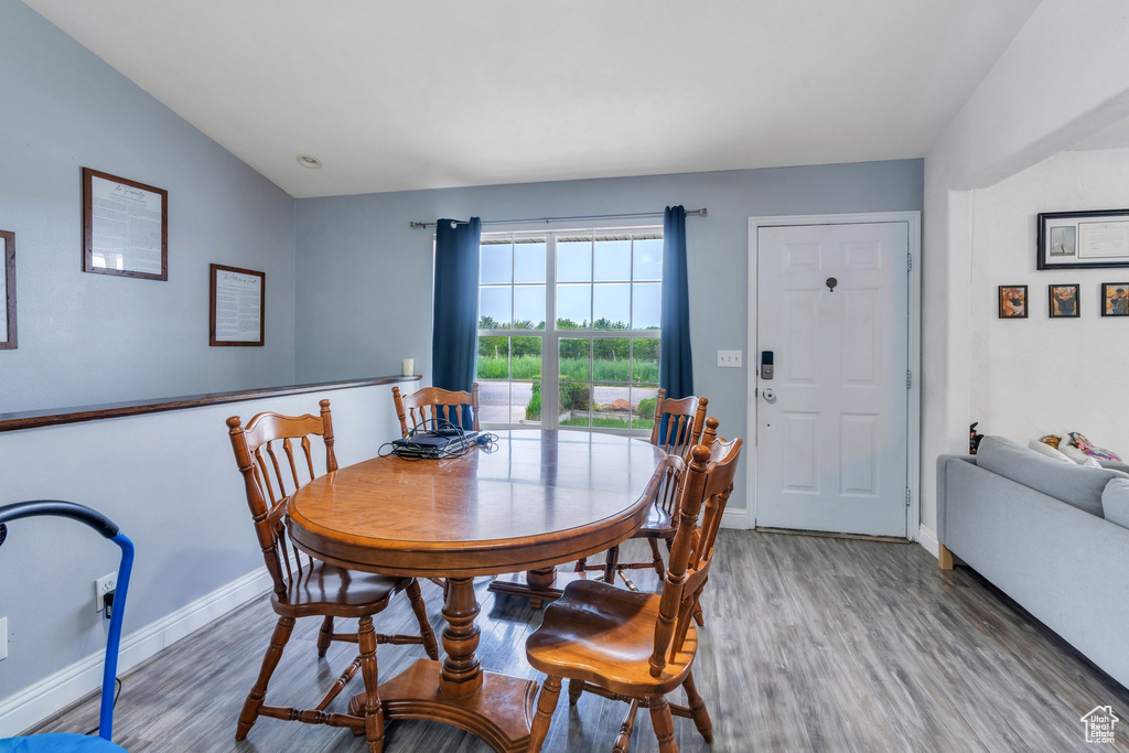 Dining space with light wood-type flooring, baseboards, and vaulted ceiling