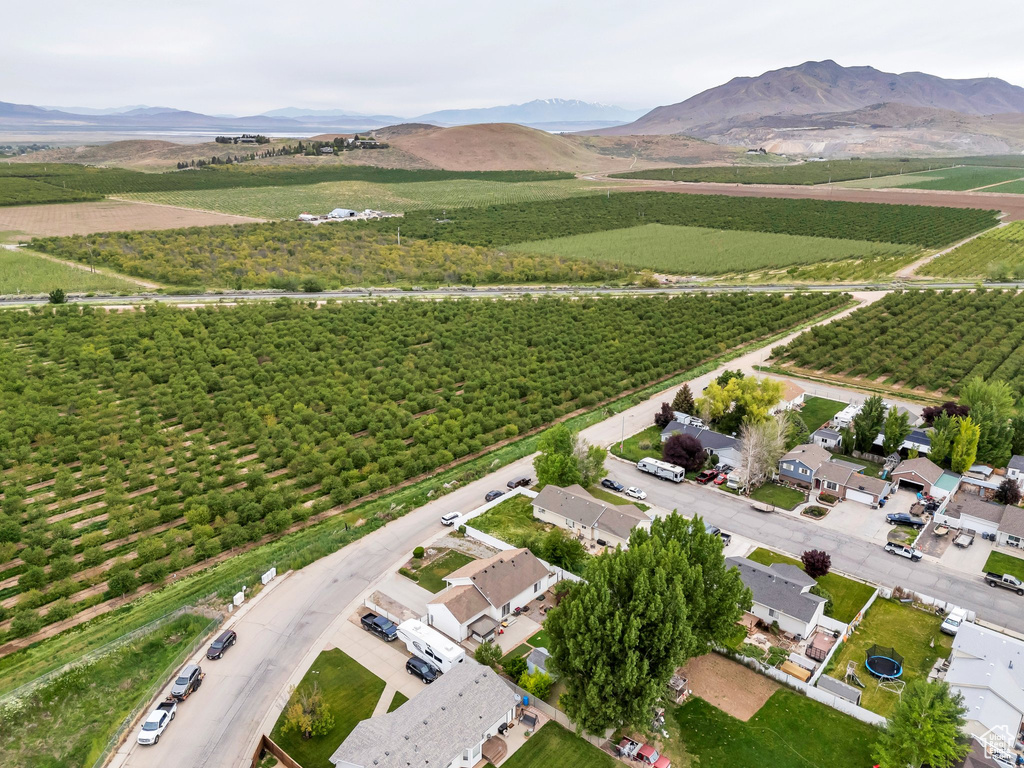 Aerial view of property and surrounding area featuring farmland, a mountain backdrop, and rural landscape