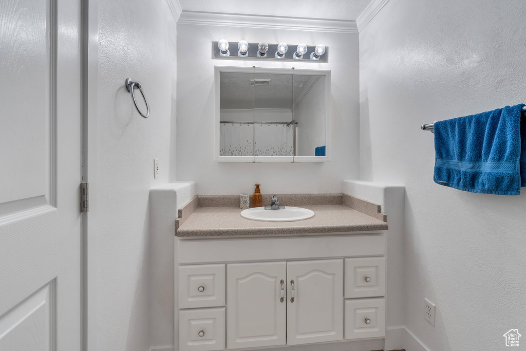 Bathroom with ornamental molding and vanity