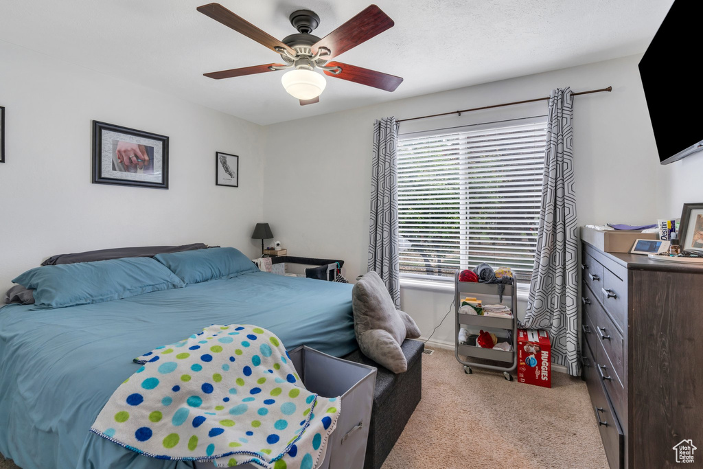 Bedroom featuring light colored carpet and ceiling fan