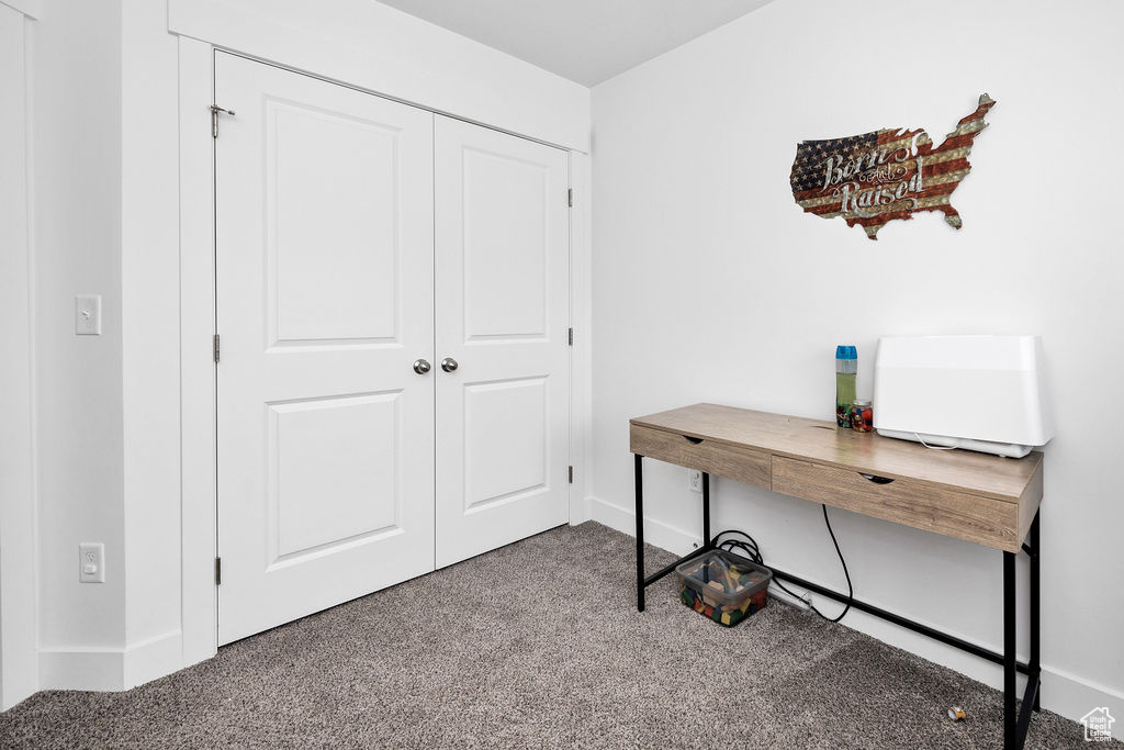 Carpeted home office featuring baseboards