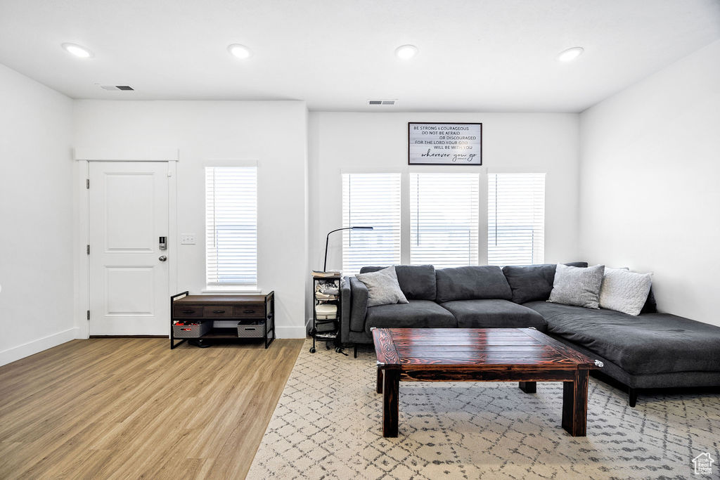 Living area with light wood finished floors, recessed lighting, and baseboards