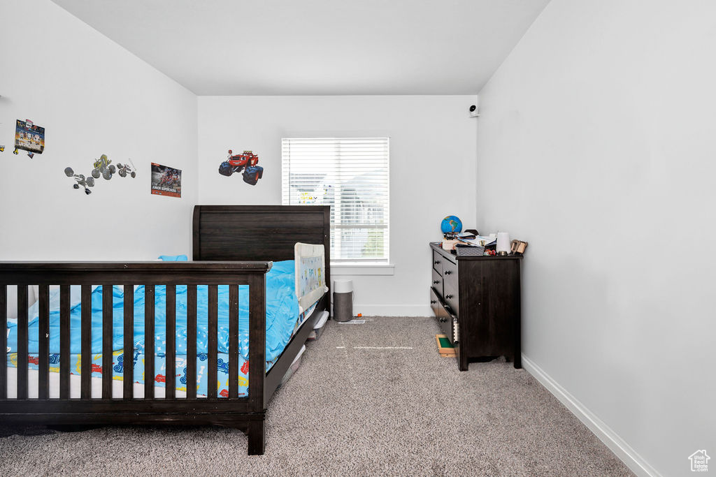 Bedroom featuring carpet and baseboards