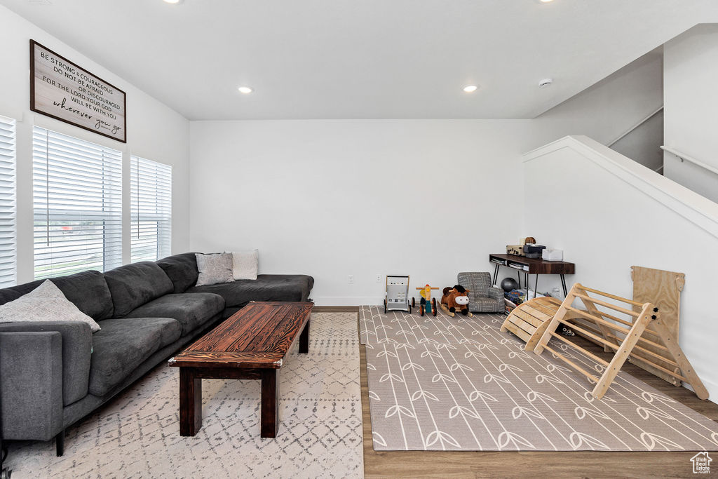 Living area with recessed lighting, wood finished floors, and baseboards
