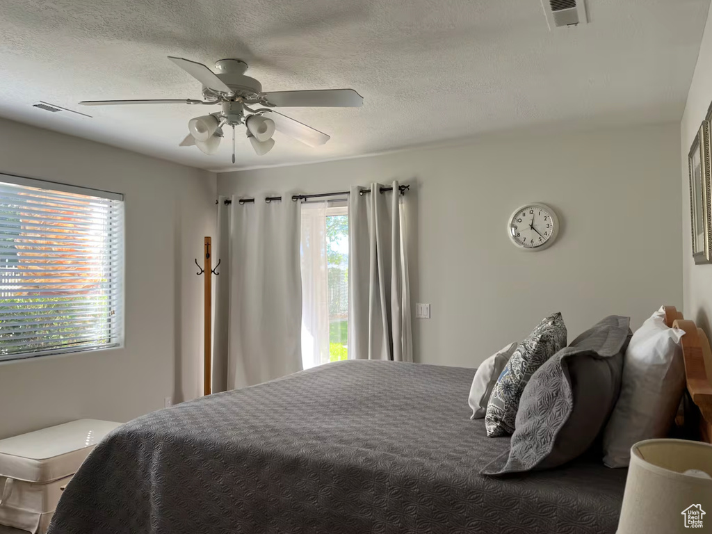 Bedroom featuring a ceiling fan and a textured ceiling
