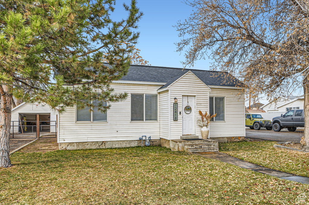 Bungalow featuring a front yard and a shingled roof
