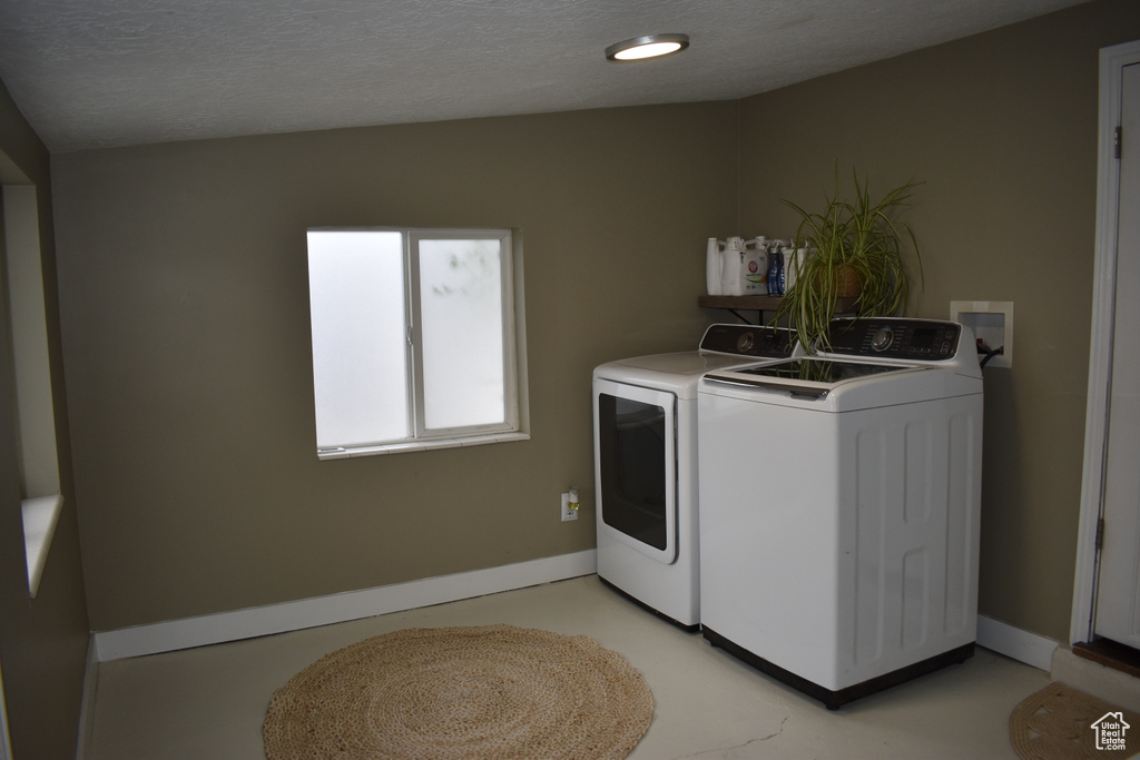 Washroom featuring separate washer and dryer and baseboards